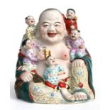 A Chinese republic group, Buddha with children 24cm (9 1/2ins) high