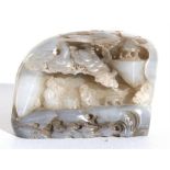 A Chinese agate bolder, with deeply carved figures playing Go under a flowering tree, 9cm (3.5ins)