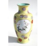 A Chinese Republic vase, decorated with birds, flowers and roundels on a pale yellow ground, 24cm (
