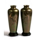 A pair of Japanese Meiji period bronze vases on stands, decorated with silver and gold inlay