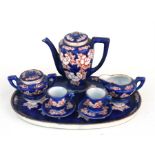 A Chinese export miniature tea set, decorated with flowers on a deep blue ground, the largest