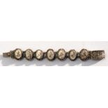 An early 20th century Chinese white metal filligree ivory panel bracelet, each panel decorated