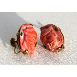 A pair of 9ct gold coral screw back earings carved with Chinese faces, 2cm (0.75ins) high.