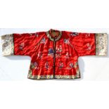 A Chinese silk short robe, embroidered with flowers on a red ground, with flower and bat decorated