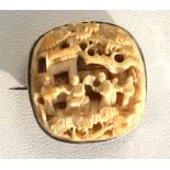 A late 19th century Chinese ivory brooch, deeply carved with figures under a flowering tree, 4cm (