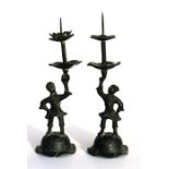 A pair of Chinese bronze figural pricket candlesticks, 27cm (10.5ins) high.