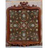 A Persian embroidered silkwork panel highly decorated with foliate scrolls, glazed and in a mahogany
