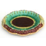 A Victorian majolica bread dish, decorated with wheat sheafs, 31cm (12.25ins) wide.