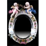 A porcelain girondelle decorated flowers and surmounted a pair of cherubs, having the blue under