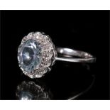 A 9ct white gold cluster ring set with diamonds around a central pale blue stone. Approx UK size Q