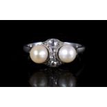 An Art Deco platinum ring set with four central diamonds flanked by two salt water pearls. Approx.