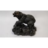 A late 19th century bronze model of a grizzly bear, standing on a rock base, signed P Mene, 23cm