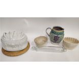 A Poole pottery decorated with grapes and vine leaves, along with two ceramic jelly moulds, a