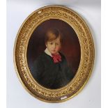 A 19th century oil on panel of a boy, in a oval gilt frame with a leaf and berry boarder, 53cm x