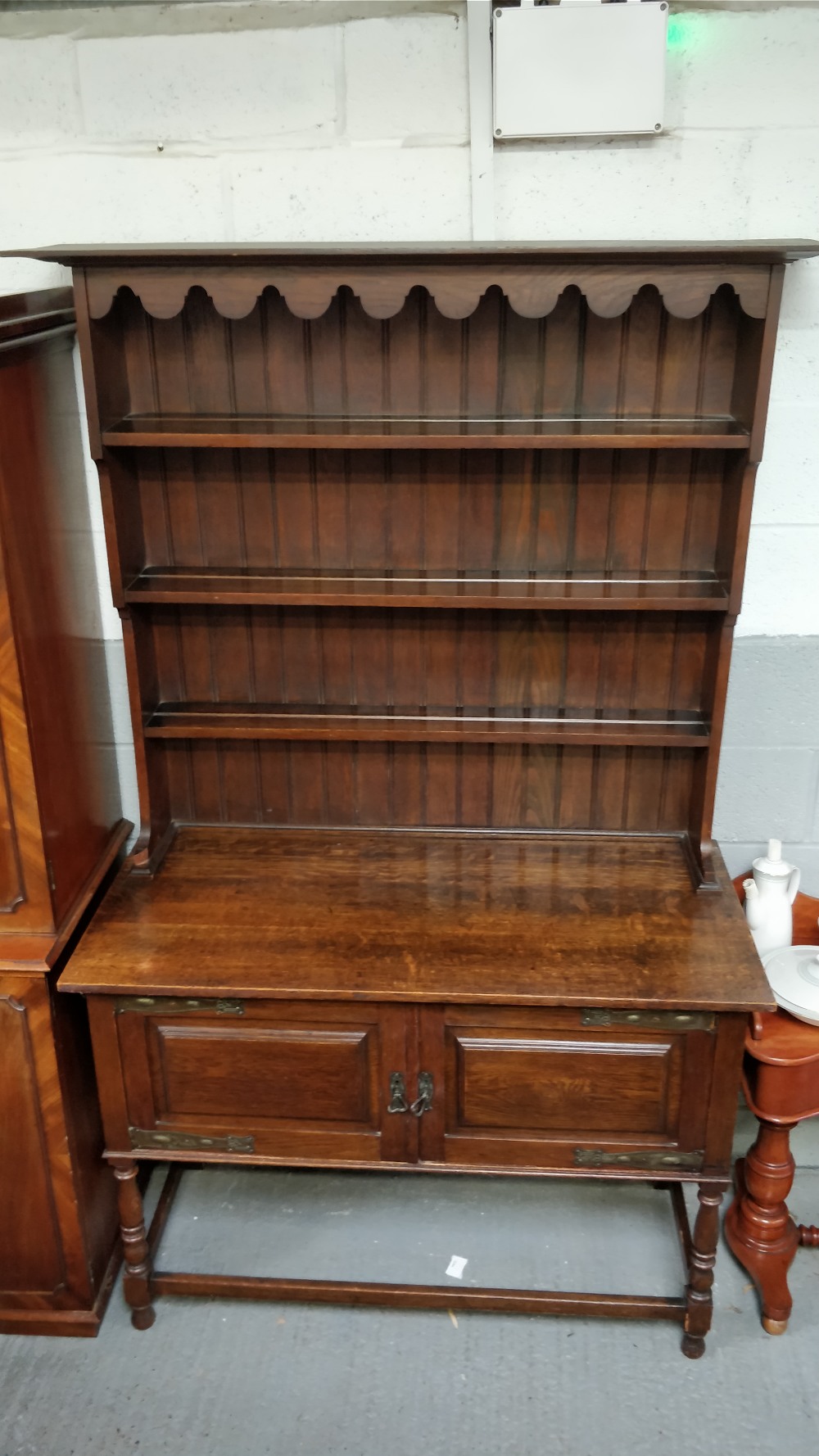 An Art Nouveau oak dresser, with fitted copper mounts and panelled top section, 205cm high, 122cm
