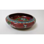 A 20th century cloisonné bowl on a red ground, decorated with flowers, 20.5cm diameter