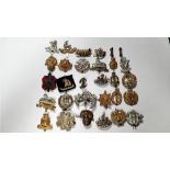 A collection of military cap badges including Somerset, Cornwall, Royal Corps Signals and various