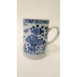 A 19th century Chinese blue and white mug, decorated with bamboo, flowers and various plants, 15.5cm