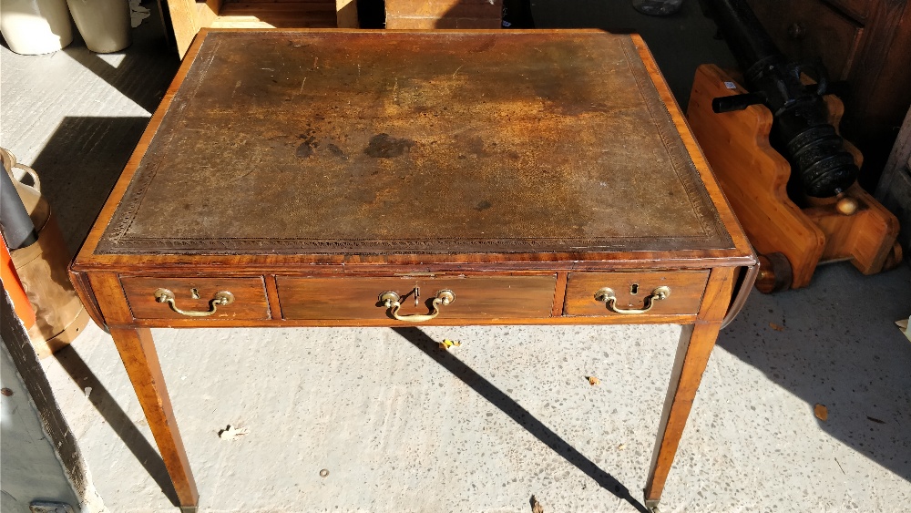 A Georgian writing desk with inlaid leather, drop leaf ends, on tapering legs and three lockable