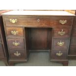An early 19th century mahogany kneehole desk, with a originals brass drop handle, single long drawer
