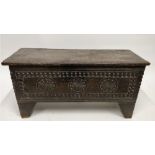 An 18th century oak coffer with carved front panel with three central motifs and carved boarders,