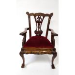 A 20th century mahogany child's chair with a drop in seat