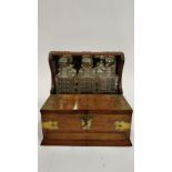 A 20th century oak tantalus, with fitted decanter section, open out lid and single drawer, with