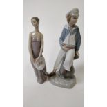 A Lladro figure of a seated boy, and a Lladro figure of a seated girl