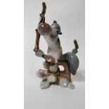 A Lladro figure of a squirrel on tree clutching a piece of fruit