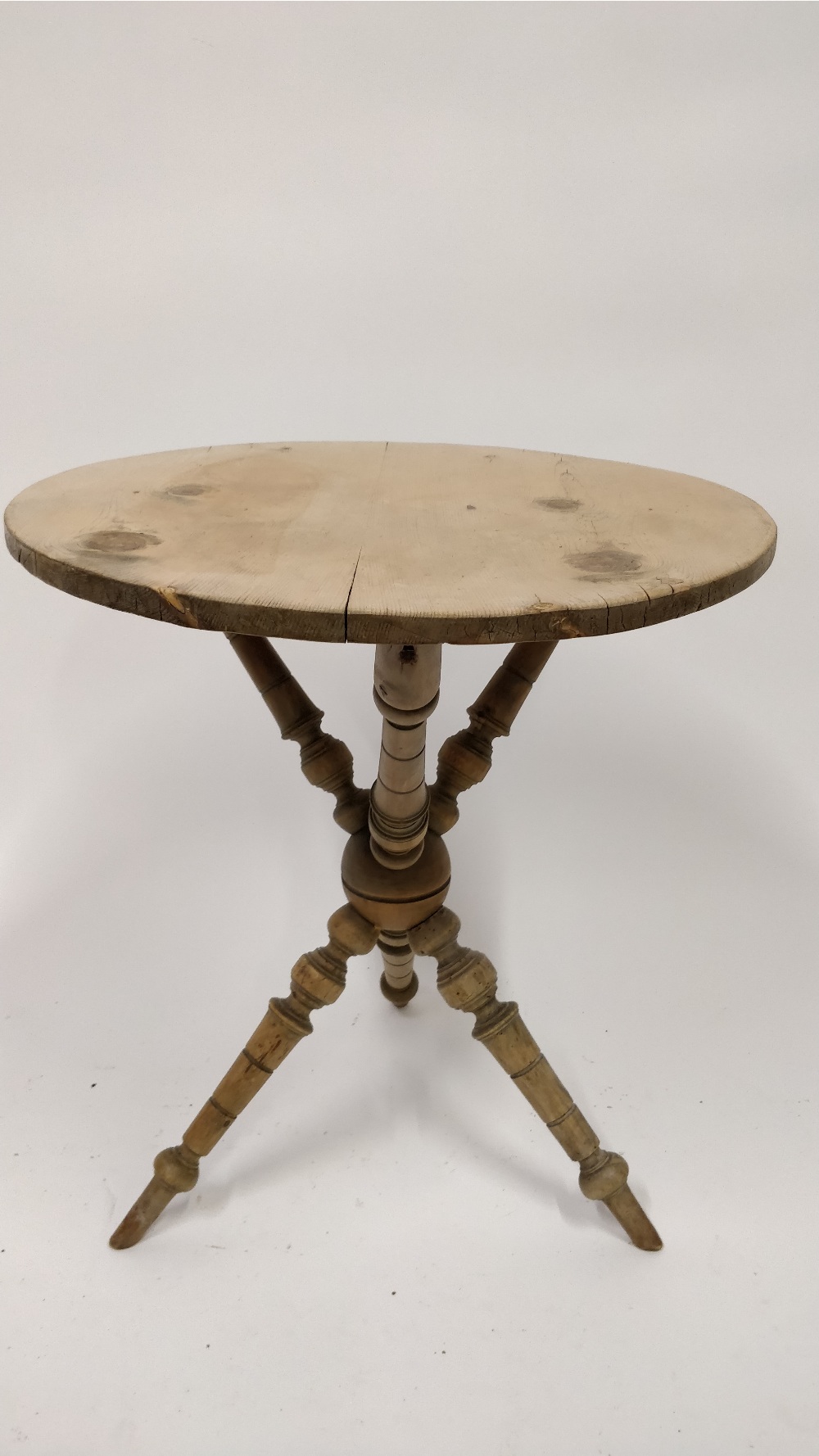 A Victorian pine cricket table, with a turned tripod base, 59cm high, 52cm diameter