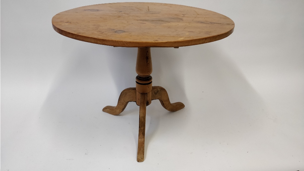 An early 20th century tilt top pine circular table, on a tripod base, 87cm diameter