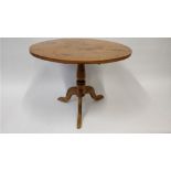 An early 20th century tilt top pine circular table, on a tripod base, 87cm diameter