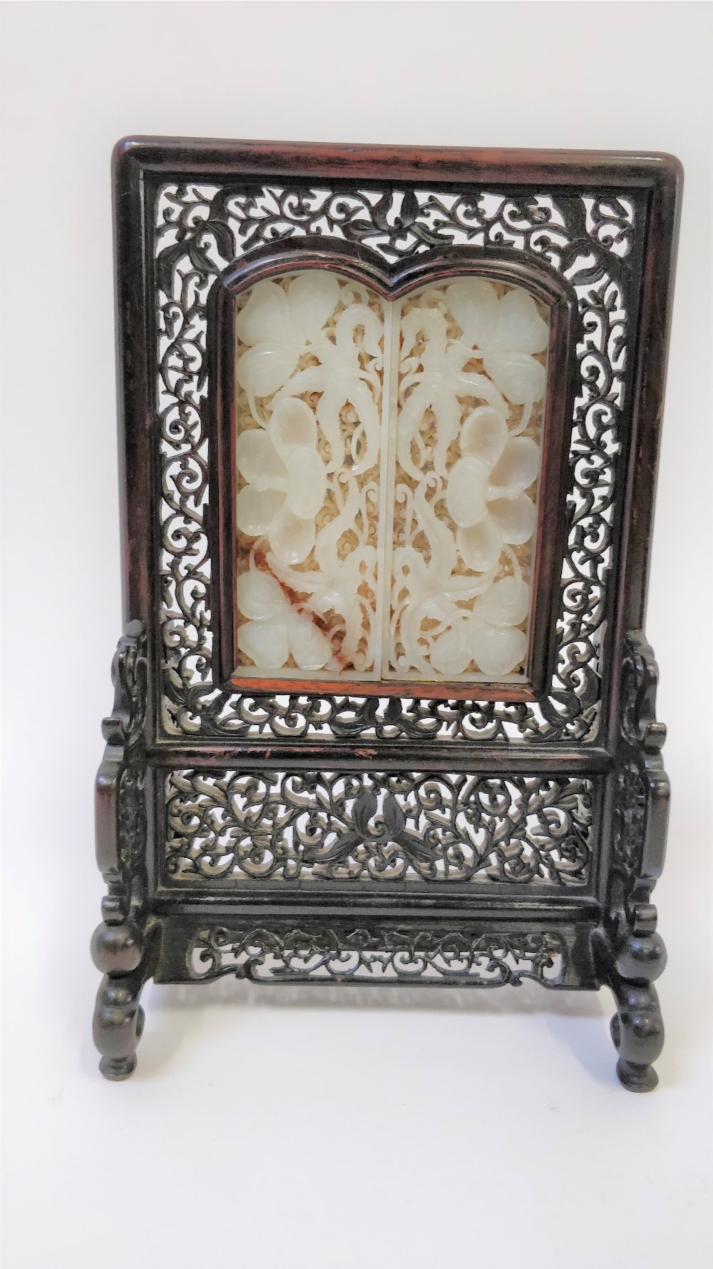 A 20th century Chinese table screen, the white jade panel decorated with flowers in a hardwood frame