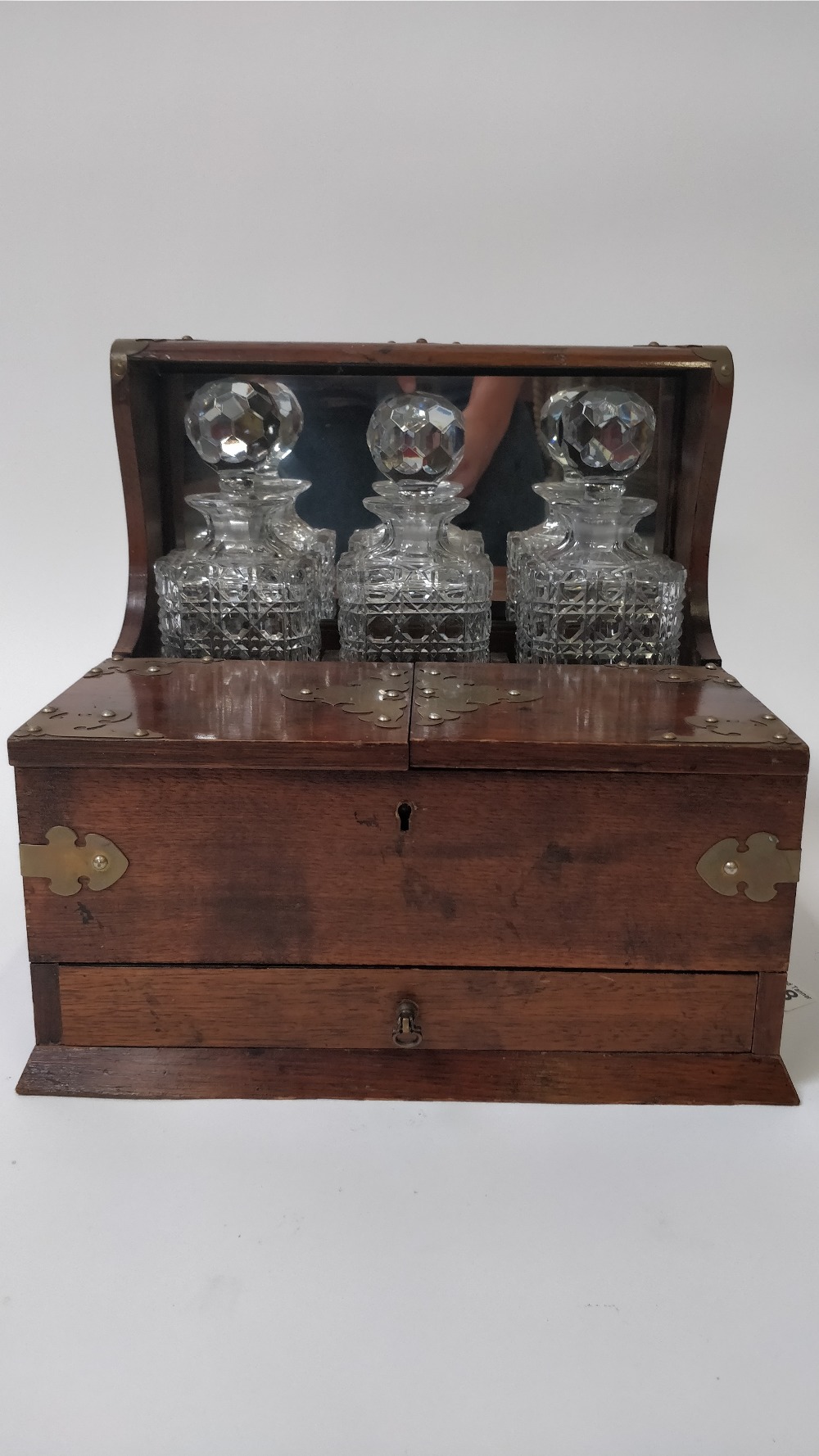 An early 20th century tantalus, in a mahogany frame with fitted section for three decanter, open