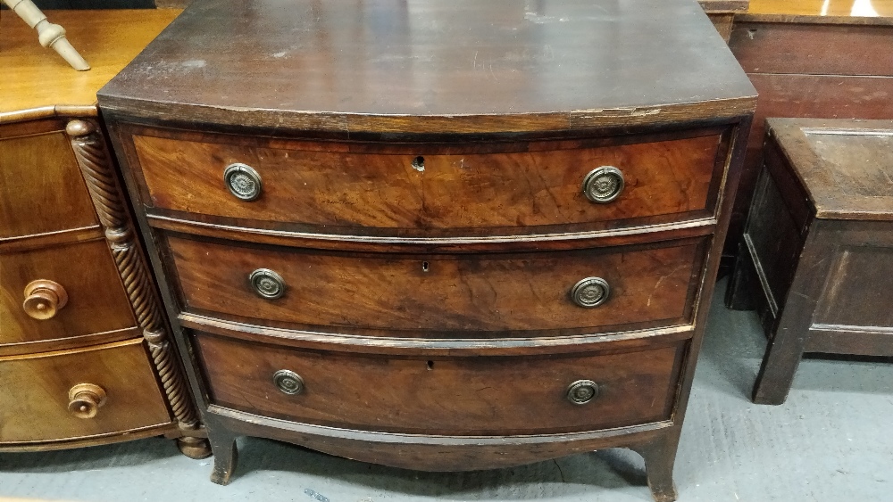 A Victorian mahogany bow front chest of drawers, of three long, on bracket feet with brass drop