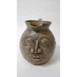 A 20th century pottery jug with a grotesque face in the style of Martin Brothers, 24cm high