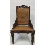 A 19th century Anglo Indian carved hardwood chair with a wicker seat and back