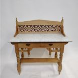 An early 20th century pine washstand, with a tiled back and white marbled top, 109cm high, 106cm