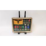 A framed display World War German/Nazi medals to include, Nazi service armband, Two WWI iron