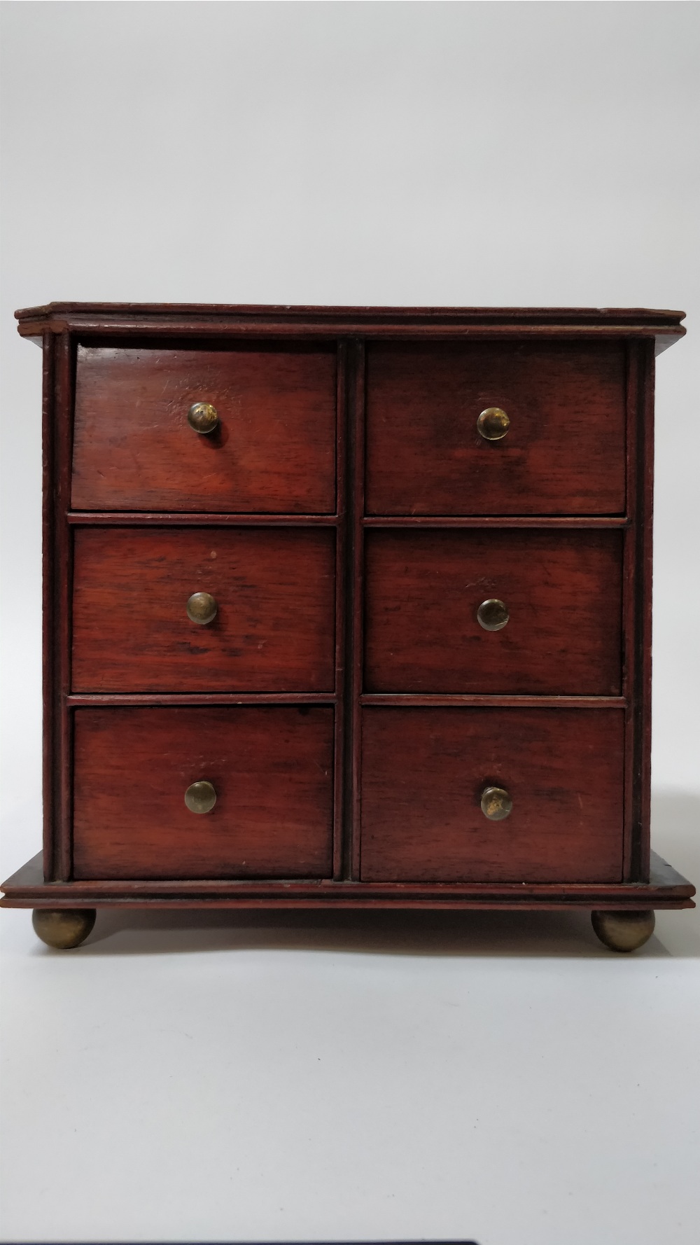 An early 20th century apprentice chest of drawers, with six small fitted drawers each with a brass