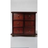 An early 20th century apprentice chest of drawers, with six small fitted drawers each with a brass