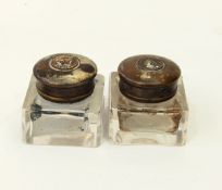 A pair of Mosley's inkwells with glass bases and brass caps
