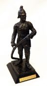 Bronzed-effect figure of a fireman with hose, on rectangular wooden base,