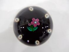 Paul Ysart glass paperweight of lampwork form, the centre decorated with a pink flower,