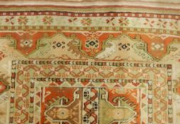 Eastern-style wool rug with hooked geometric and stylised floral decoration in shades of cream,