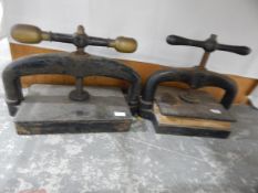Two cast iron book presses with screw mechanisms