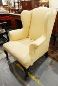 Antique wing armchair in yellow damask cover,