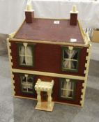 Painted wooden doll's house with red brick detailing and castellated decoration,