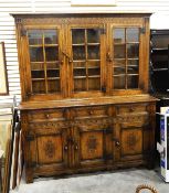 20th century oak dresser, the upper section enclosed by three bi-glazed doors, over board base,