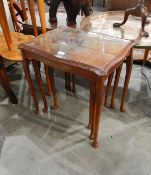 A nest of three mahogany tables with glass inset surfaces